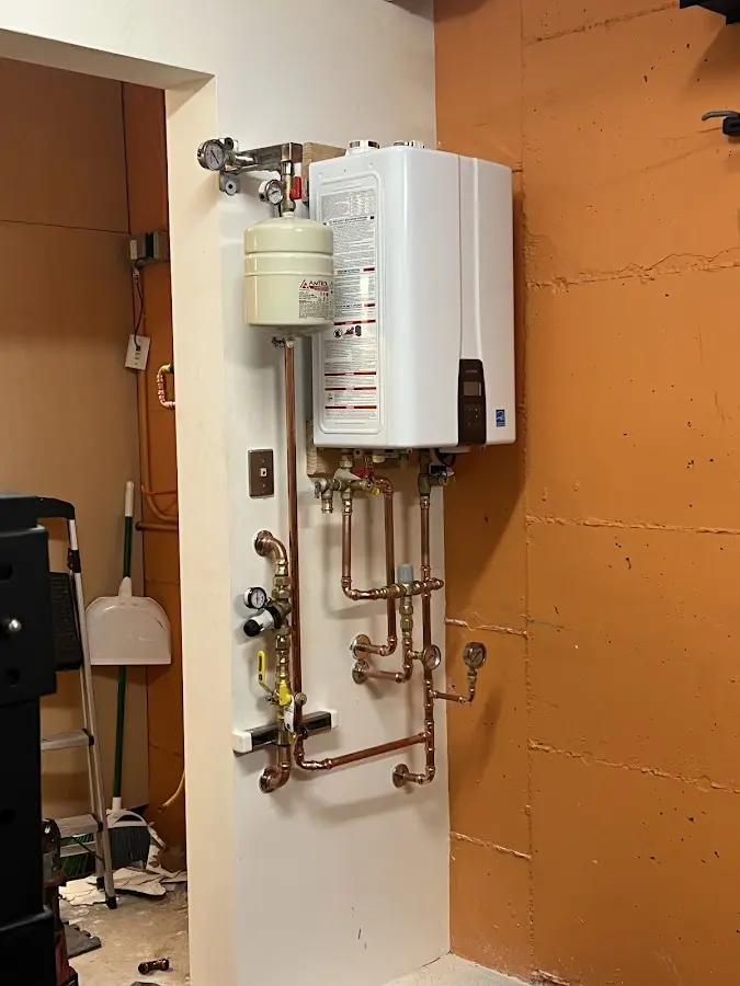 Plumbing technician inspecting water heater connections in Des Moines